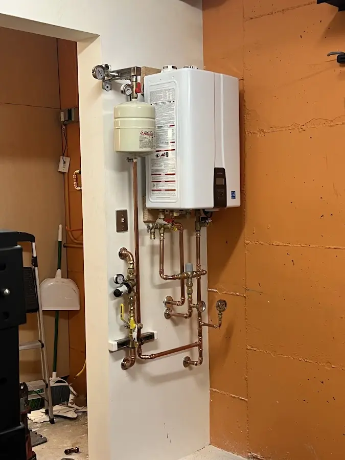 Plumbing technician inspecting water heater connections in Bithlo